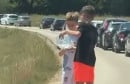 Dječaci dijelili vodu putnicima koji su čekali u koloni na granici u Vinjanima Gornjim